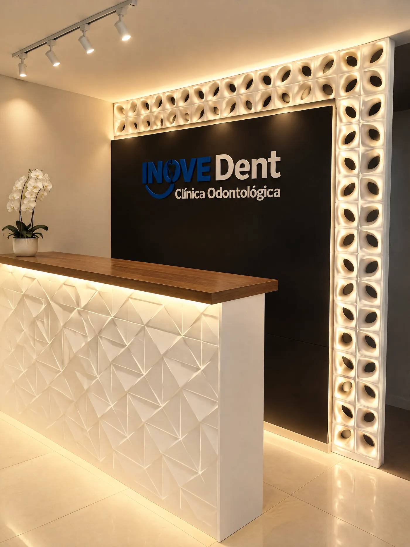 Recepção da InoveDent: balcão branco em relevo, parede preta com o logo e moldura de cobogó iluminada